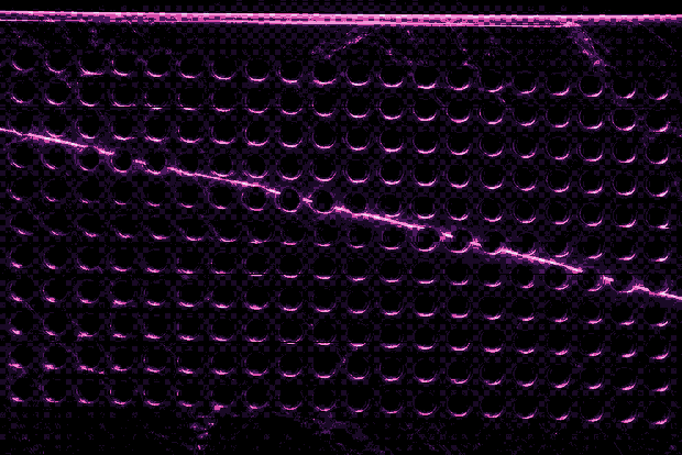A speaker grille cut into the agent's shell, printed through the wall's mesh.
